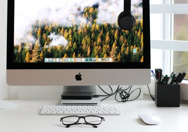 turned on silver iMac with mouse and keyboard